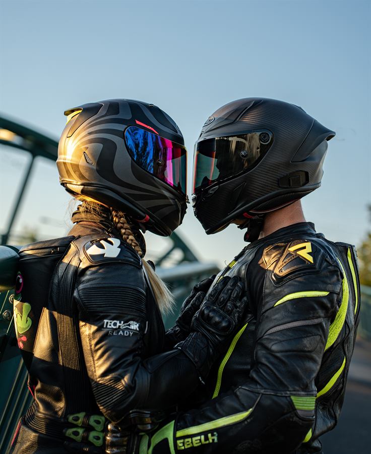 Motorkářský pár s helmami u sebe