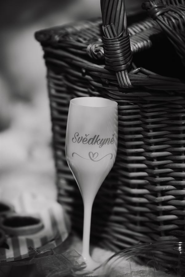 Sklenička s nápisem Svědkyně – černobílá fotografie